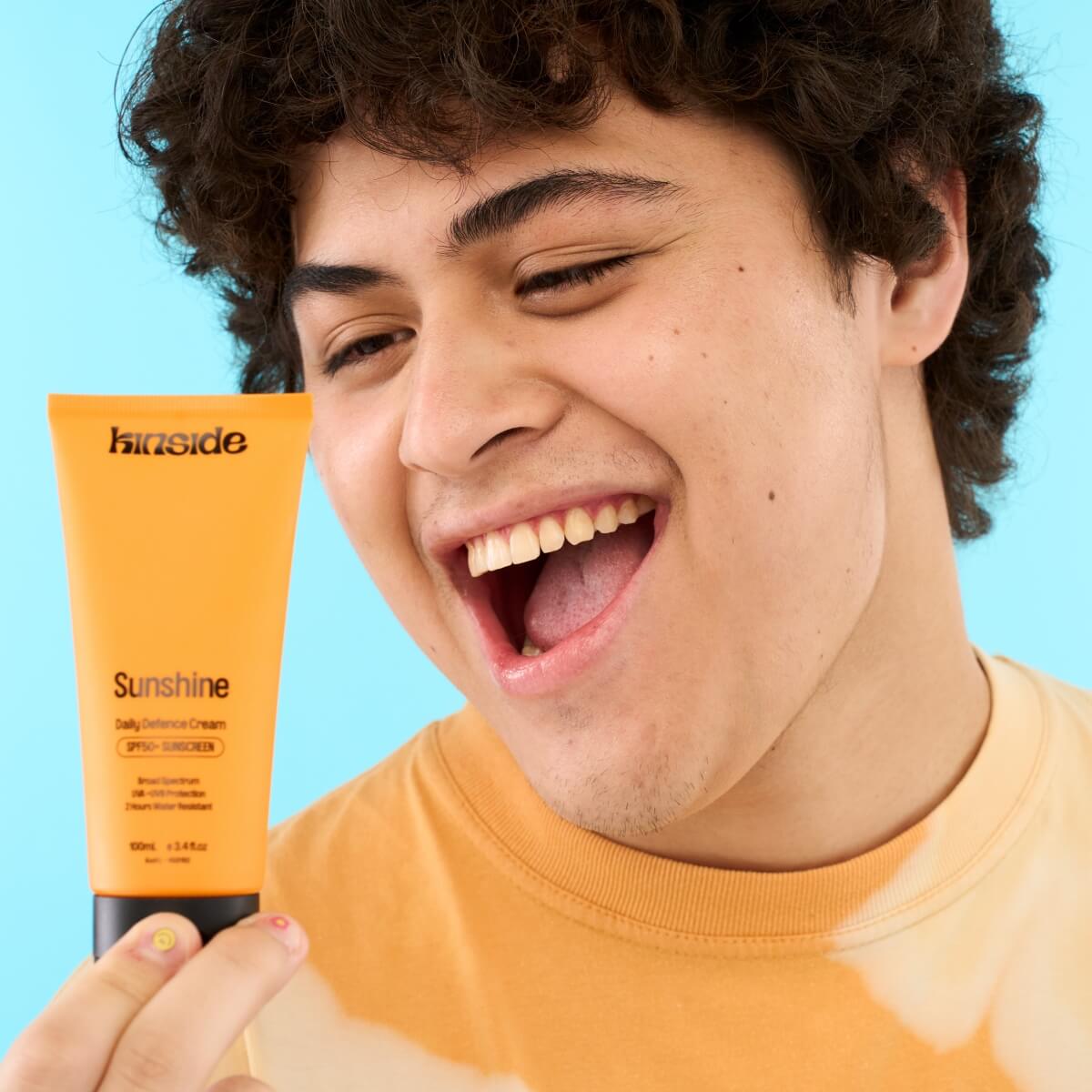 Teenager applying Kinside Sunshine Daily Defence SPF50+ sunscreen