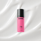 Juicy Face Hydrator bottle on a coloured background